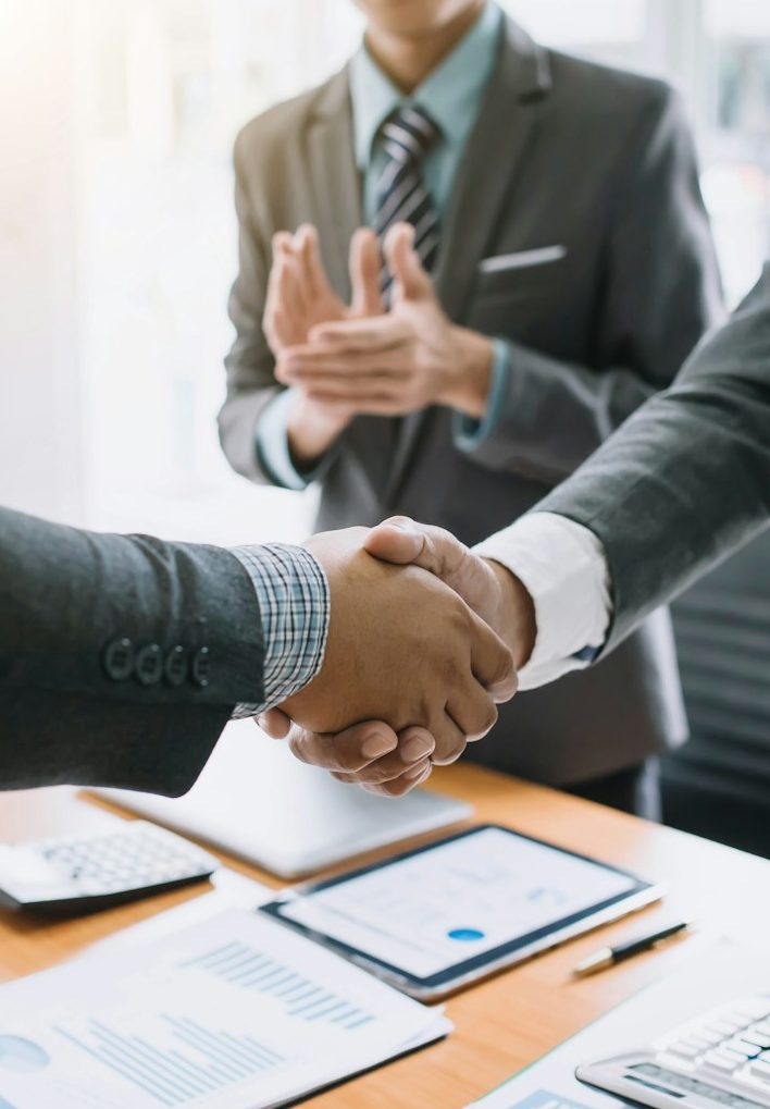 Zwei Personen schütteln sich die Hände in einem Geschäftsbüro.